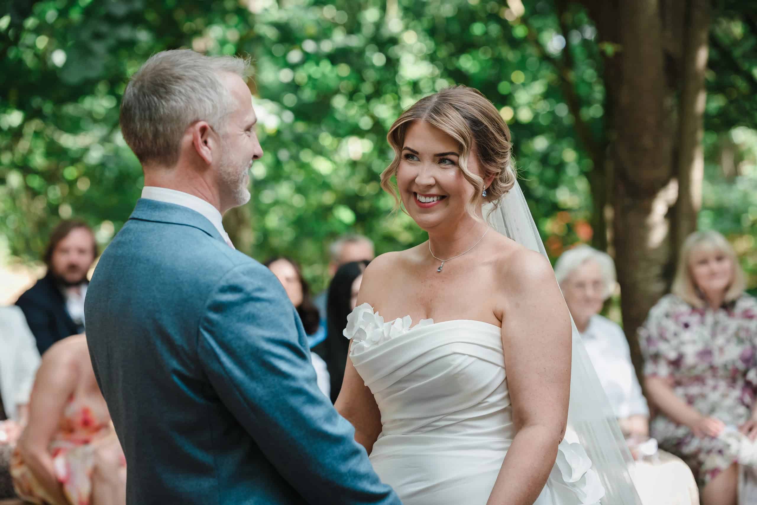 Bride and groom exchange vows face-to-face during outdoor ceremony. - Paul Phipps-Williams Photography