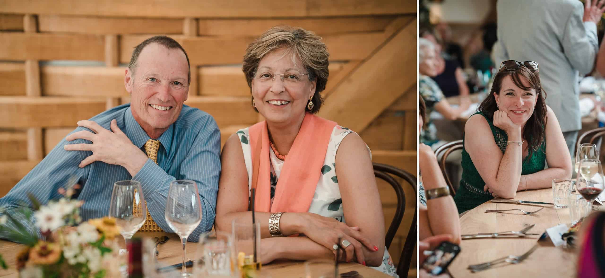 Two adults smiling at the camera while seated at a dining table during a formal event. — Wedding at Cripps Barn, Cirencester