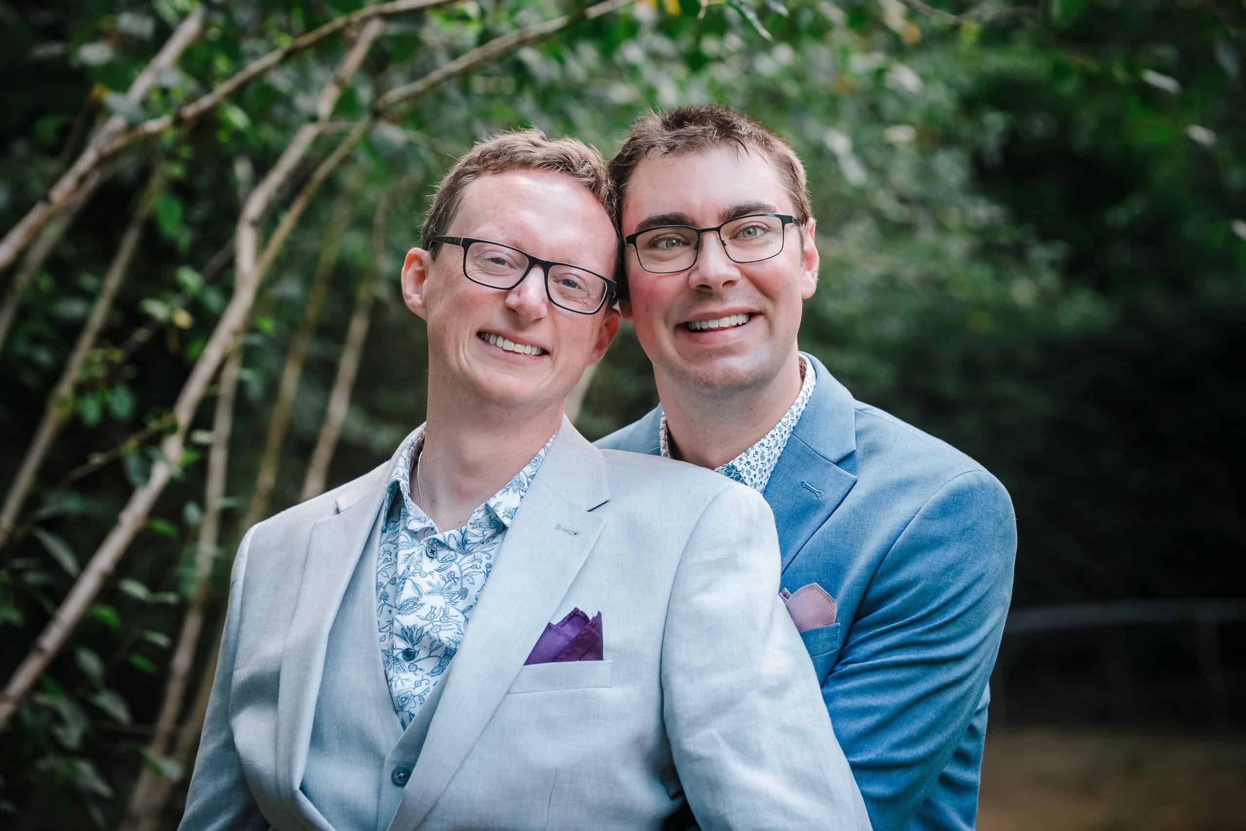 Two men posing together for a portrait, smiling at the camera with arms around each other. — Wedding at Cripps Barn, Cirencester