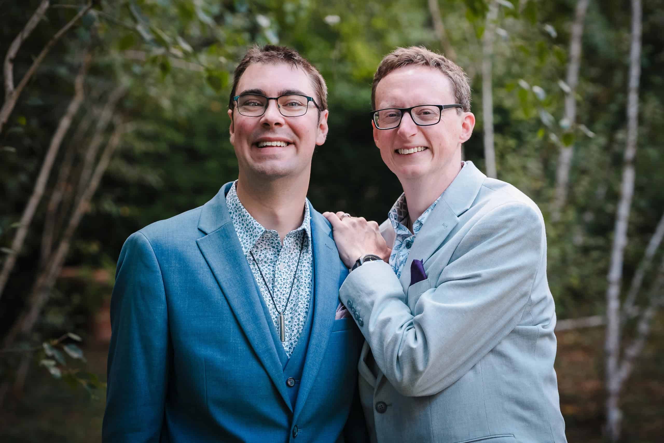 Two men posing together with their arms around each other's shoulders, smiling at the camera. — Wedding at Cripps Barn, Cirencester